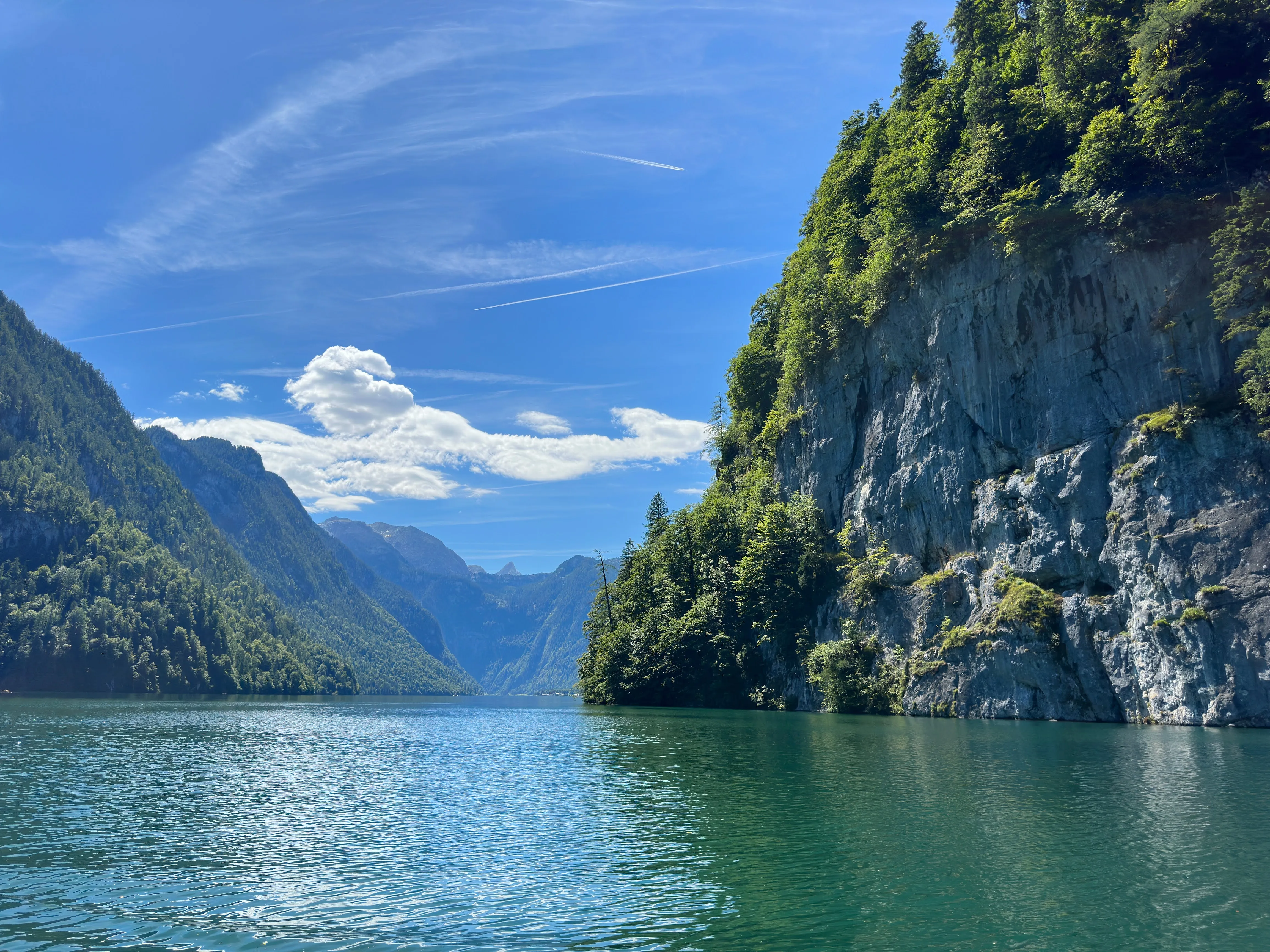 Mountain lake with forest cliffs and blue sky